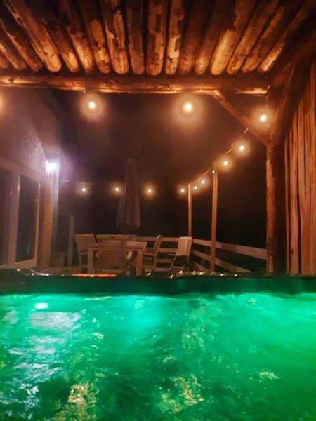 a swimming pool in a house with a table and chairs at La maison du sourire 2 in Durbuy