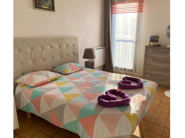 - une chambre avec un lit et des chaussons violets dans l'établissement le studio du centre ville, à Annecy
