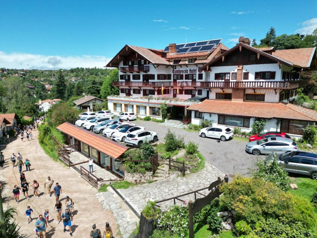 a group of people walking in front of a building at Hotel La Cumbrecita in La Cumbrecita