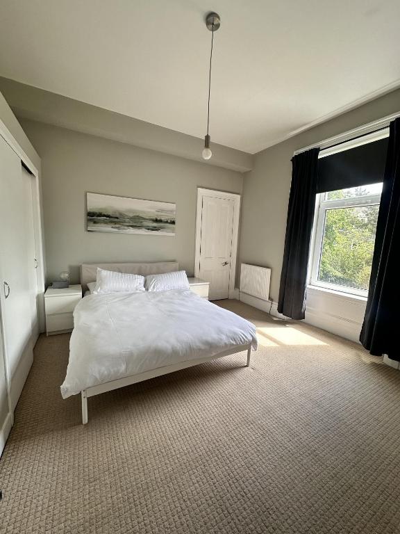 Un dormitorio con una cama blanca y una ventana. en Springbank Apartment, en Aberdeen
