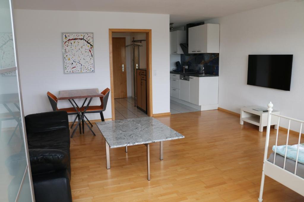 un soggiorno con tavolo e cucina di Ferienwohnung Bella Vista a Eimeldingen
