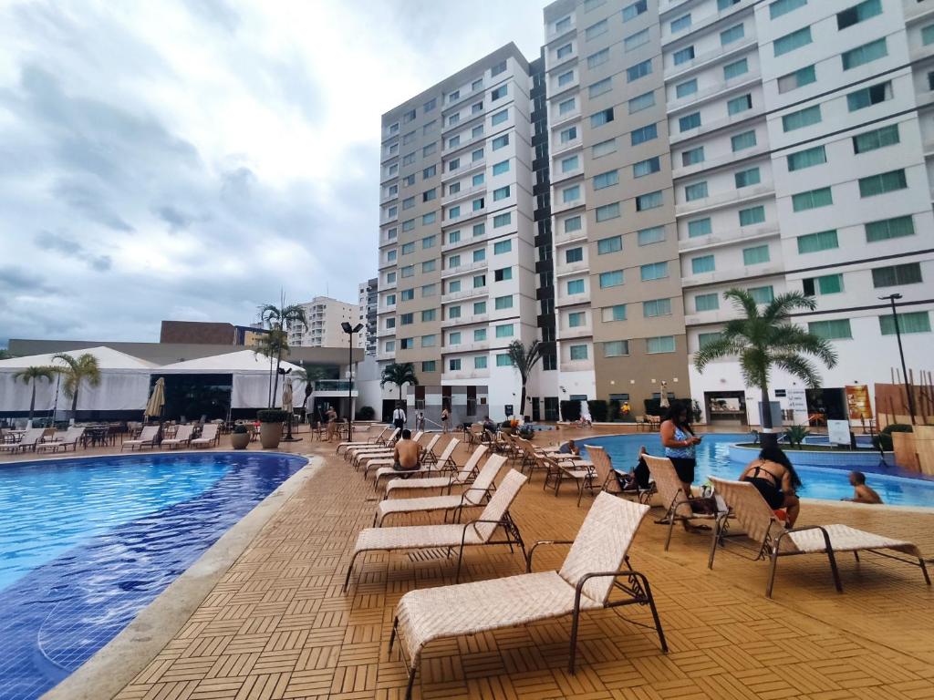 una piscina de hotel con tumbonas y edificios en Riviera Park, en Caldas Novas