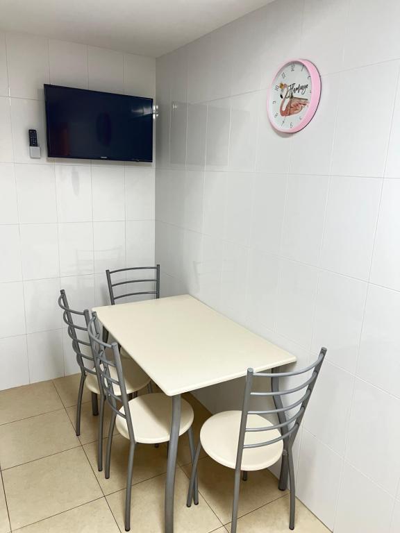 佩尼斯科拉APARTAMENTO SITUADO EN EL CENTRO CON 3 HABITACIONES, DISPONE DE AIRE ACONDICIONADO Y WIFI A 150m DE LA PLAYA Y EL CASTILLO的桌子、椅子和墙上的时钟