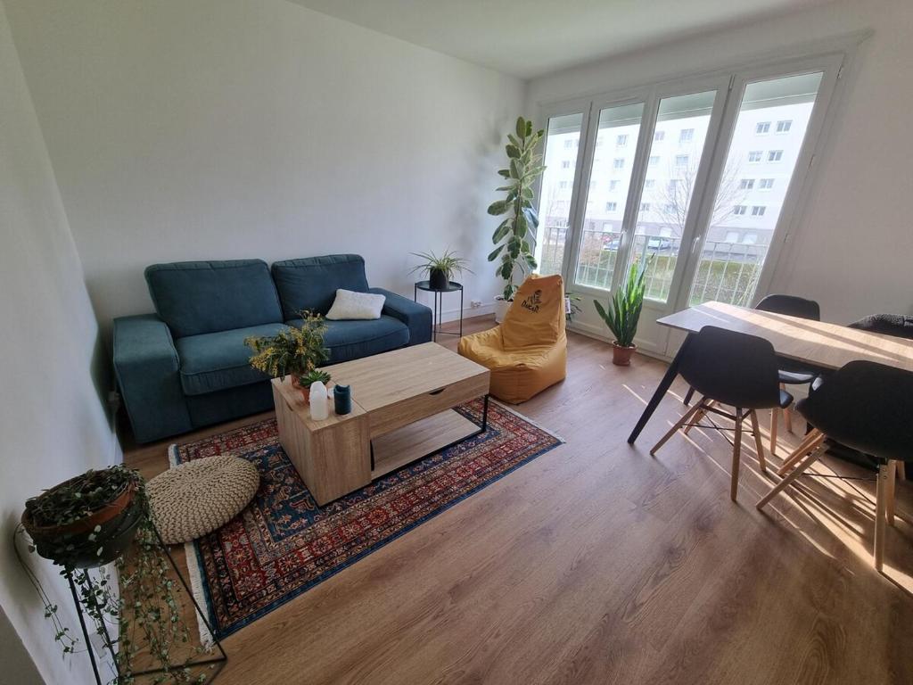 un salon avec un canapé bleu et une table dans l'établissement Chambre chez l'habitant, à Nantes