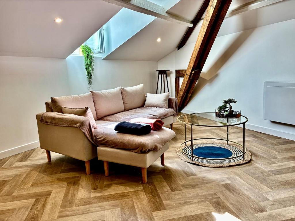 ein Wohnzimmer mit einer Couch und einem Glastisch in der Unterkunft Le SILVA Centre ville Lumineux Wifi et Netflix in Périgueux