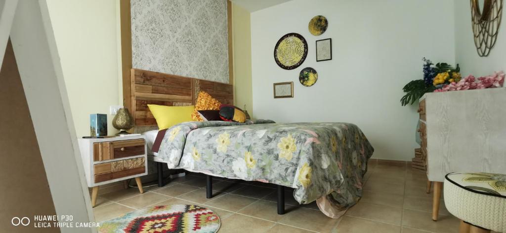 een slaapkamer met een bed en een tafel met een sprei bij Wind Rose Duplex in Gran Tarajal