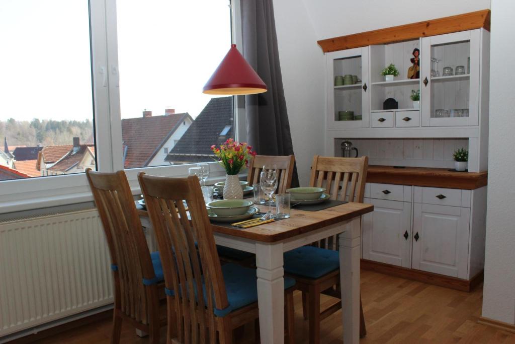 a dining room with a table and chairs and a window at Hexnquartier in Braunlage