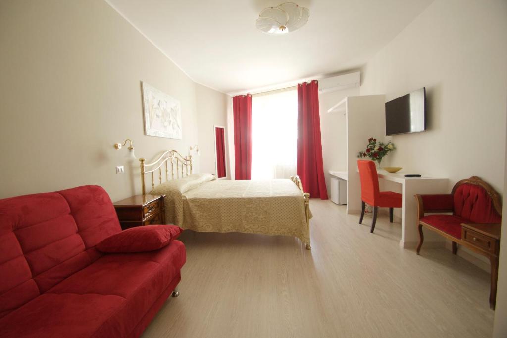 a living room with a red couch and a bed at B&B La Perla di Roma in Rome