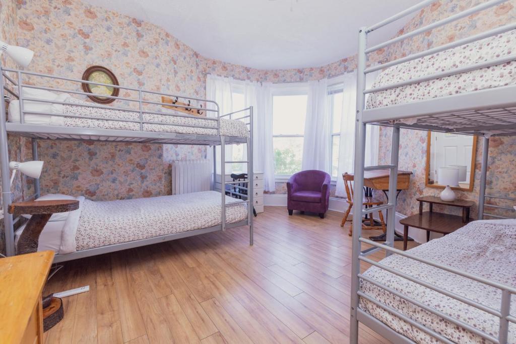 a bedroom with two bunk beds and a desk at HI Charlottetown Backpacker's Inn in Charlottetown