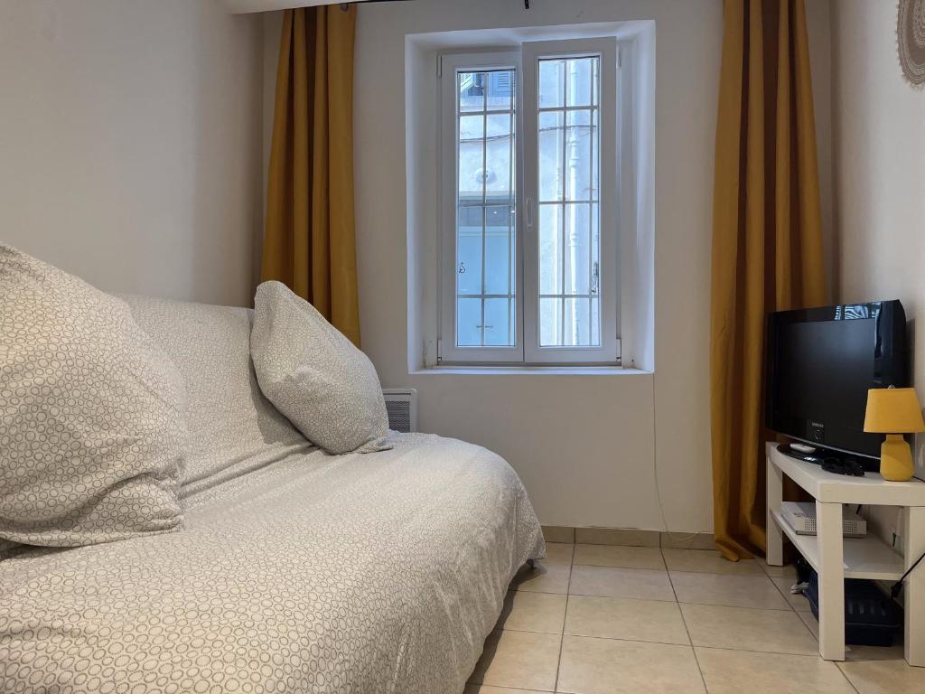 une chambre avec un lit, une télévision et une fenêtre dans l'établissement Studio équipé confort proche de toutes commodités, à La Seyne-sur-Mer
