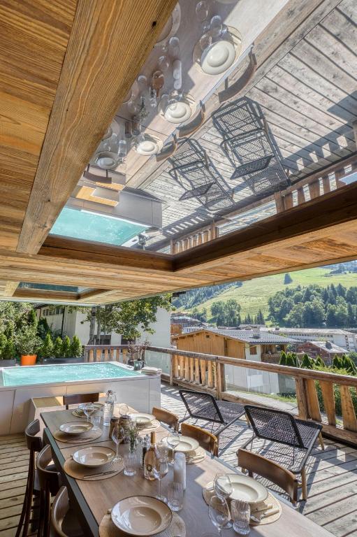 une salle à manger avec une table et des chaises sur un balcon dans l'établissement Les Chalets de La Clusaz - Appartement Le Faon, à La Clusaz