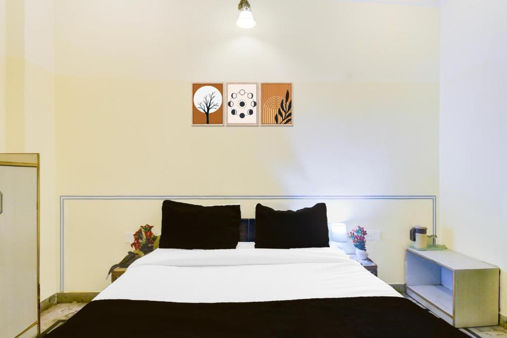 a bedroom with a large bed with white sheets at Super Hotel O Sikar Road Jaipur Formerly Garg Niwas in Jaipur