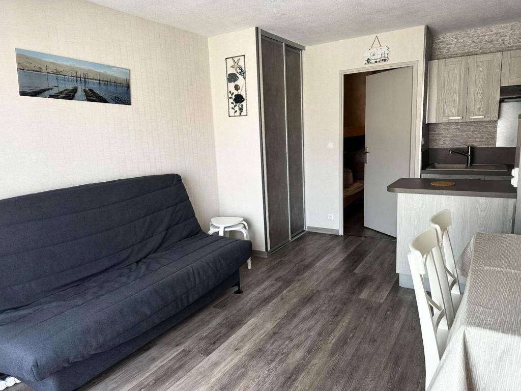 un salon avec un canapé et une cuisine dans l'établissement Résidence La Goëlette - T1 fonctionnel avec parking, proche gare et plage MAE-9224, à Arcachon