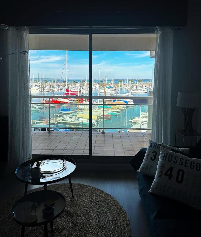 - un salon doté d'une grande fenêtre offrant une vue sur le port de plaisance dans l'établissement Résidence Pieds Dans L Eau - T2 tout confort avec vue bassin – 4 personnes MAE-0204, à Arcachon