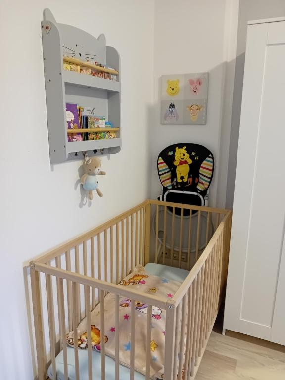 a baby crib with a chair in a room at Gästewohnung zum Heiligen Grund in Meißen