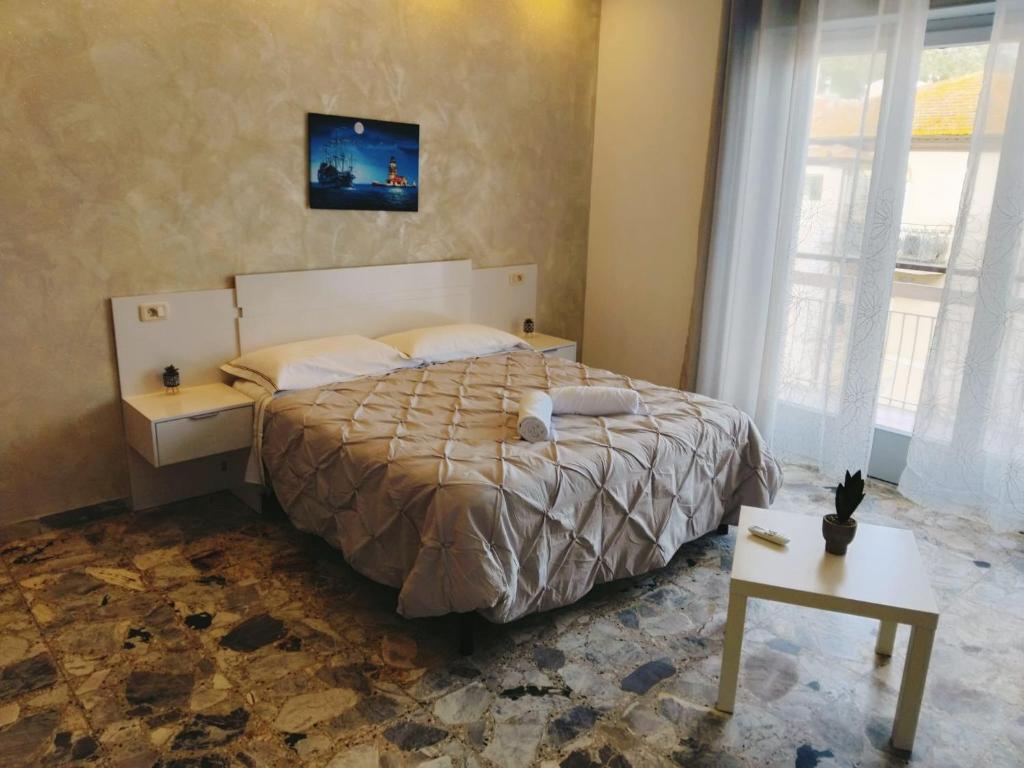 a bedroom with a bed and a table and a window at Casamia-guest house Porto Ercole in Porto Ercole