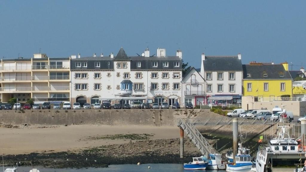 un groupe de bâtiments et de bateaux dans un port dans l'établissement Hotel De La Mer, à Quiberon