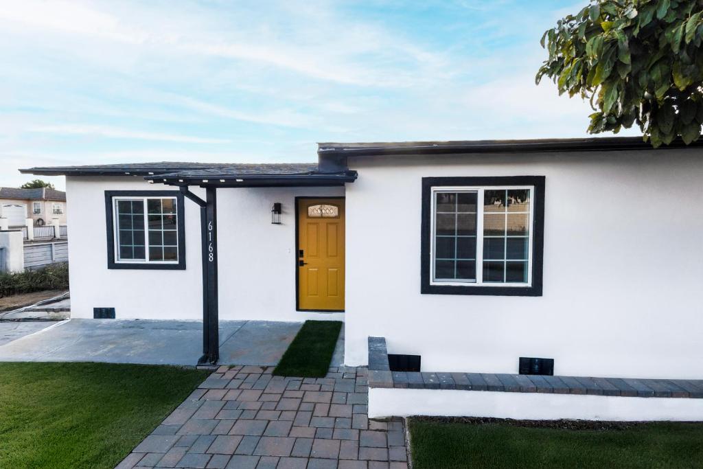 a white house with a yellow door at Exotic home Cumberland street by sdstay in San Diego