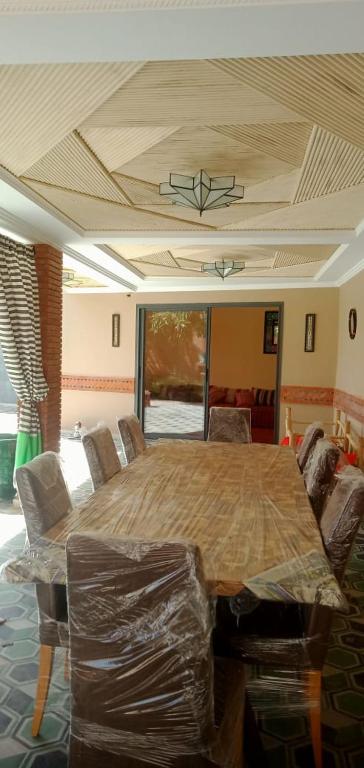 a dining room with a large wooden table and chairs at House Medina Villa in Salene