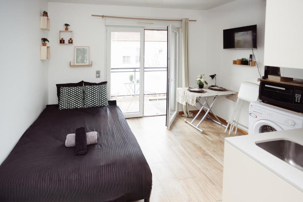 a bedroom with a bed with a tie on it at Studio cosy 28 mn aéroport CDG 34 mn chatelet in Livry-Gargan
