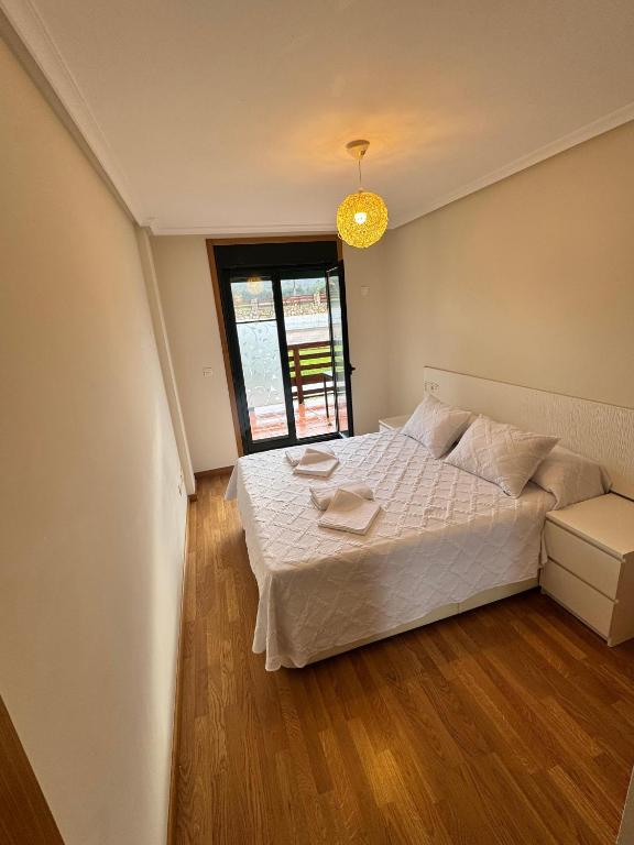 a bedroom with a white bed and a window at Apartamento Herosa 2 Spa in San Miguel de Reinante