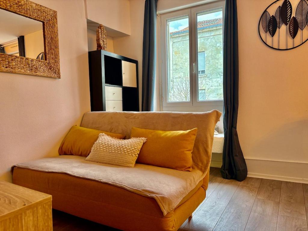 un salon avec un canapé et une fenêtre dans l'établissement LaTierraCota Centre ville Wifi Netflix, à Périgueux