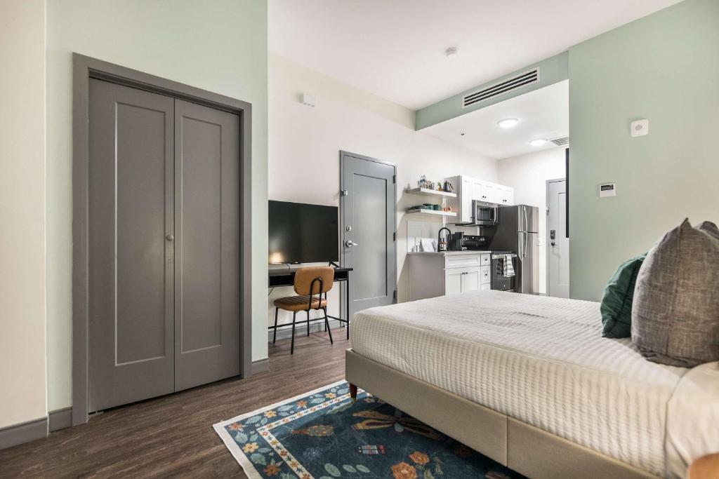 Un dormitorio con una cama grande y una cocina. en Dynamic Stay Connected Comfort Steps from Atrium, en Macon