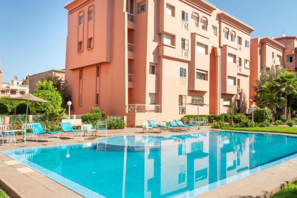 ein Schwimmbad vor einem Gebäude in der Unterkunft Appartement de luxe Résidence Majorelle in Marrakesch