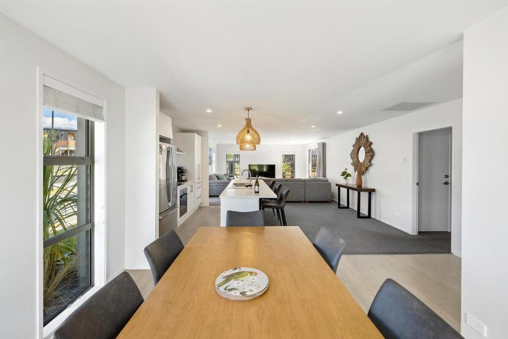 a dining room and living room with a wooden table at Mountain View - 2 Bedroom House in Queenstown