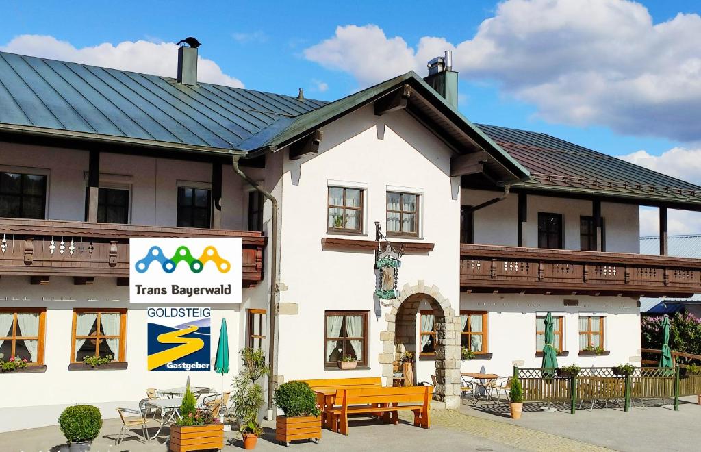 a building with a sign in front of it at Pension Philippsreut "Zum Pfenniggeiger" Am Goldsteigwanderweg in Philippsreut