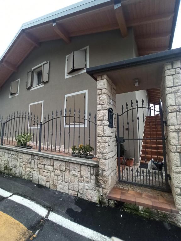 a house with a gate and a stone fence at Mary House in Ossimo