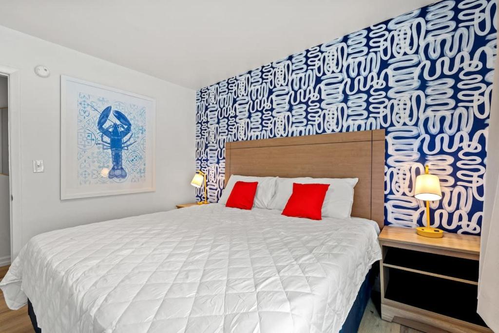 une chambre avec un grand lit blanc avec des oreillers rouges dans l'établissement Cabana Beach #4 Condo Steps from the Beach, à Myrtle Beach