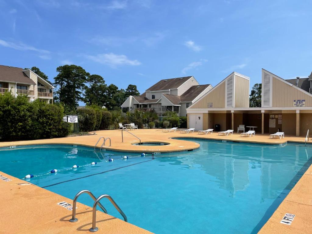 a large swimming pool in front of some houses at Bay tree lovely one bedroom condo in Little River