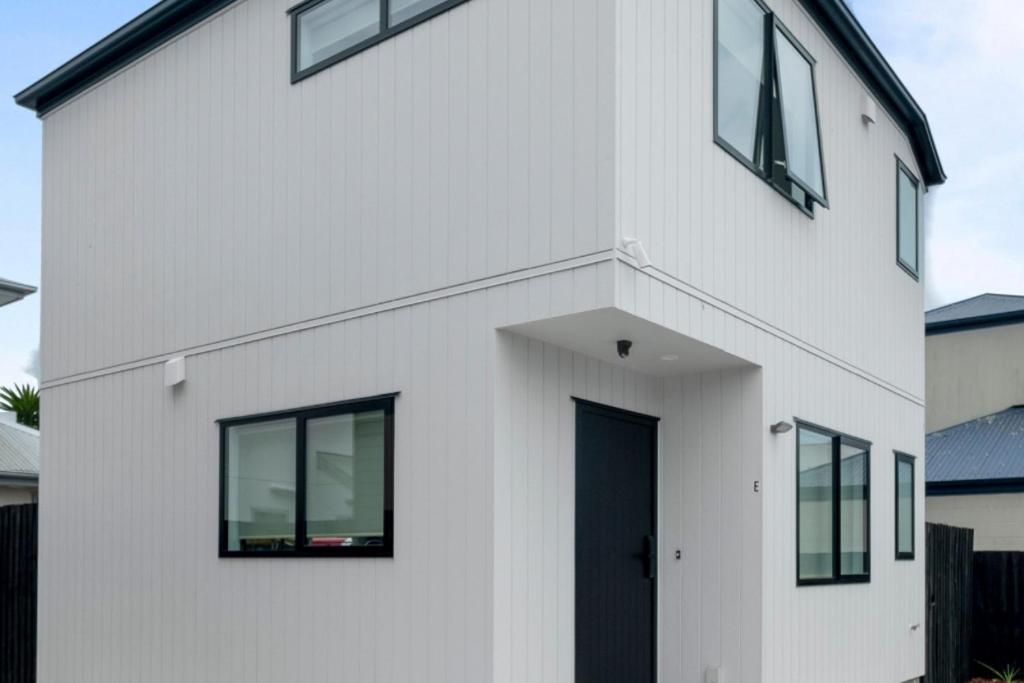Weißes Haus mit schwarzer Tür und Fenstern in der Unterkunft Brand New 2BR Home in City in Christchurch