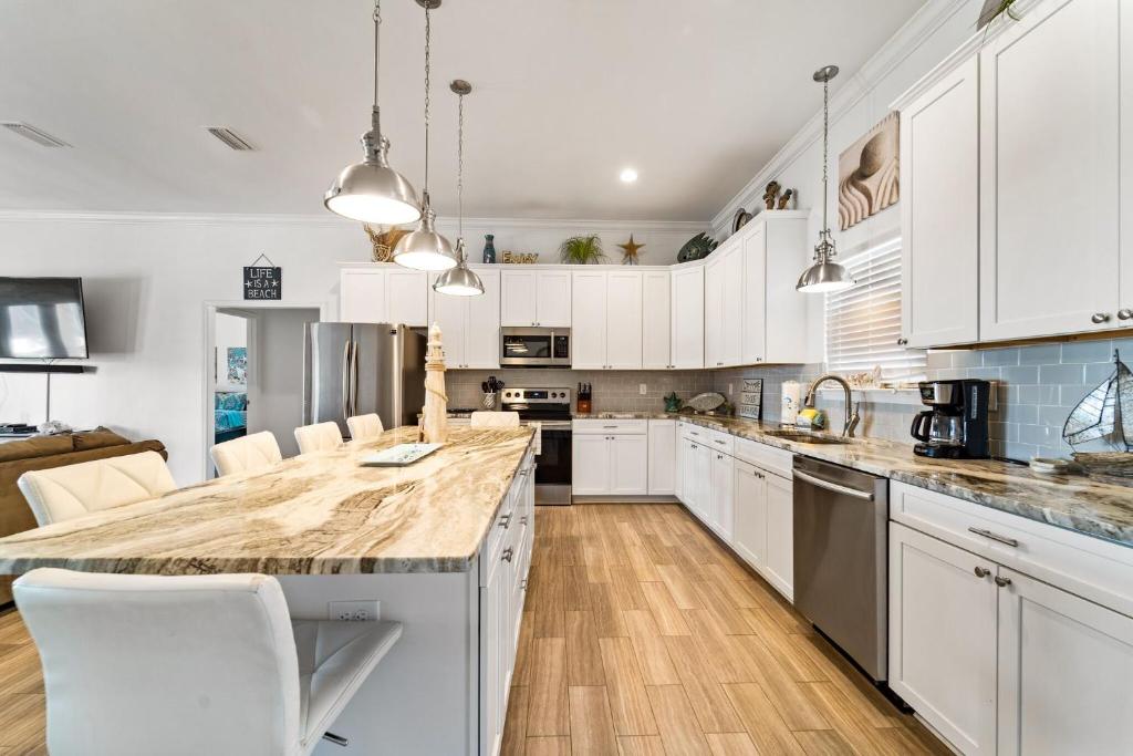 eine Küche mit weißen Schränken und einer großen Insel in der Unterkunft Newer Large Beachside 6 Bedroom House 3000 Sq Ft Sleeps 22 in Dauphin Island