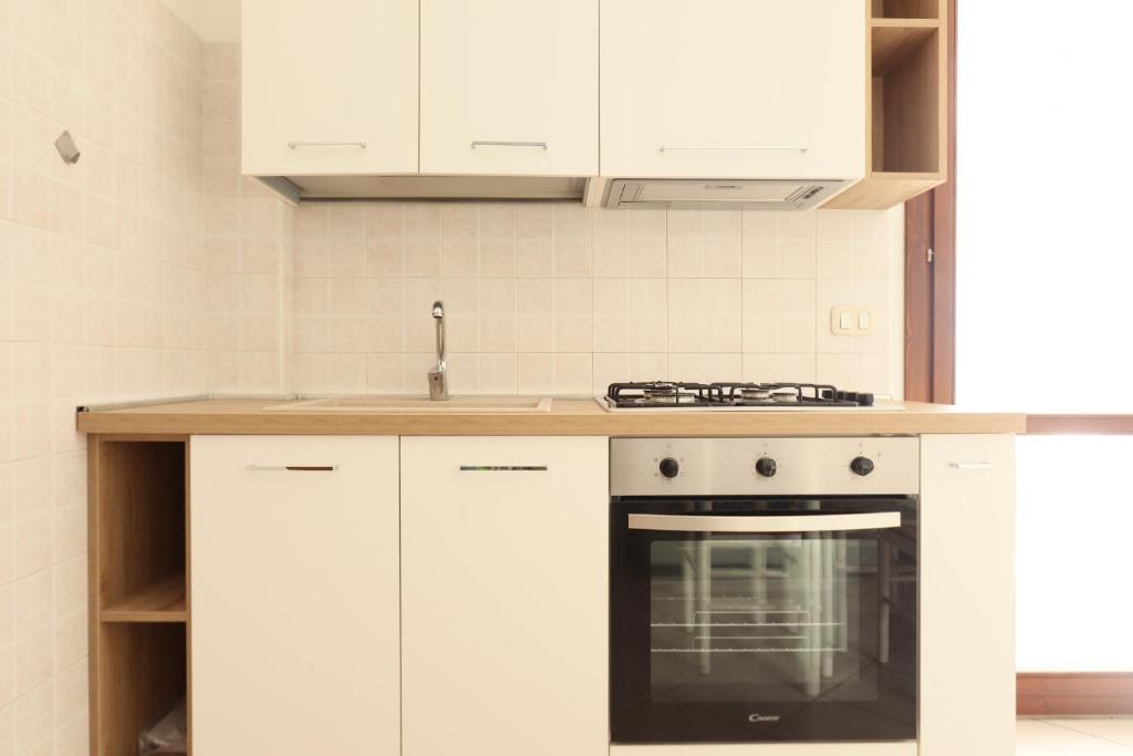 a kitchen with white cabinets and an oven at ModernShore - Oltremare in Tortoreto Lido