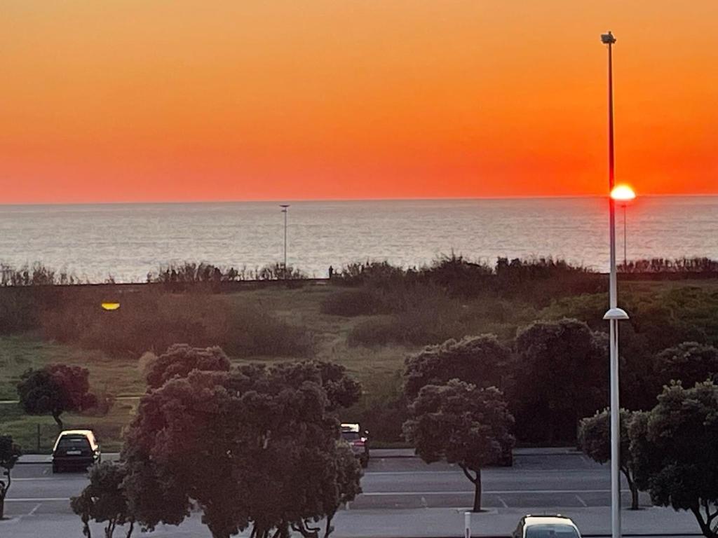 ein Parkplatz mit Sonnenuntergang über dem Meer in der Unterkunft Vila Mar Guest House in Vila do Conde