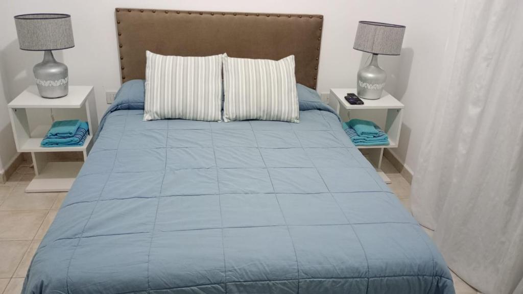a bedroom with a blue bed with two night stands at Departamento Temporario en Tres Arroyos in Tres Arroyos