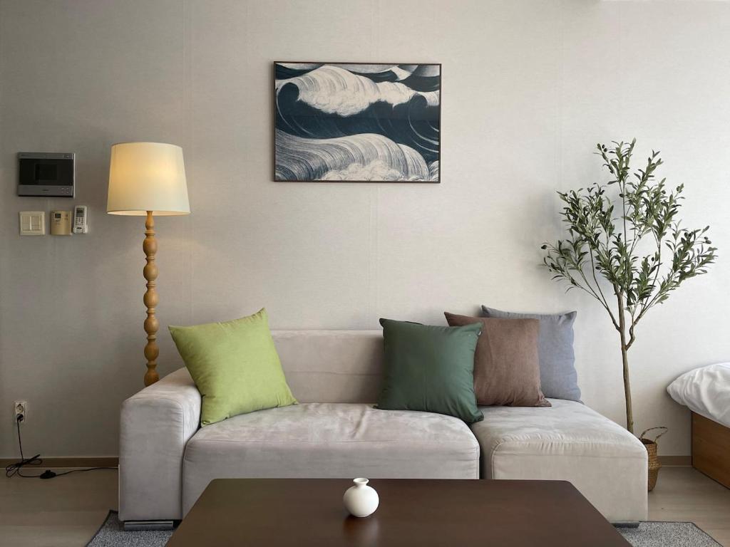 a living room with a couch and a table at 5sec from station, cosy house in Seoul