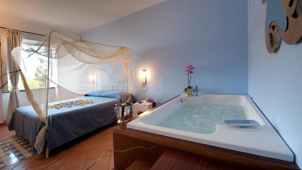 a bedroom with a bath tub and a bed at Albergo 'La Vigna' in Procida