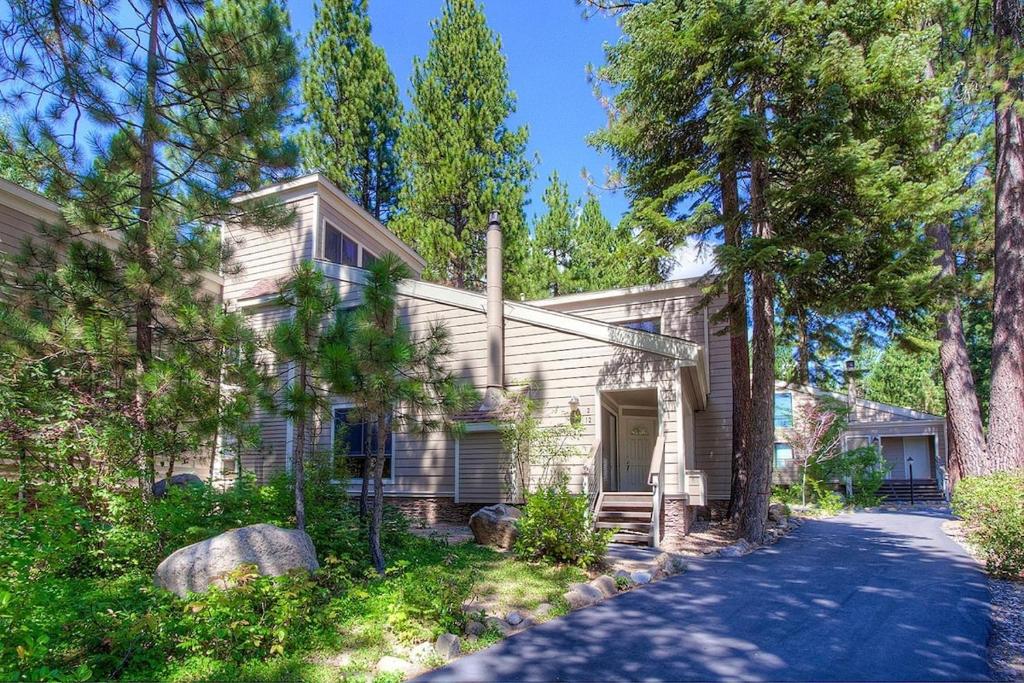 a house with trees in front of a driveway at Cartwright Corner Condo townhouse in Incline Village