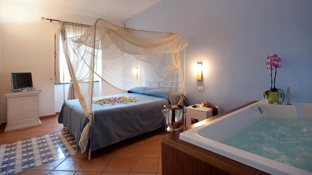 a bedroom with a bed and a bath tub at Albergo 'La Vigna' in Procida