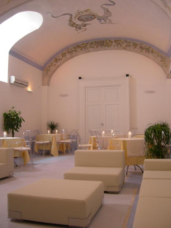 a dining room with tables and couches and tables and chairs at Albergo 'La Vigna' in Procida