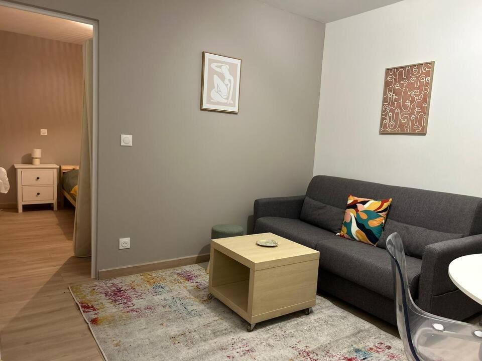 a living room with a couch and a table at Appartement 4 personnes Proche Centrex & Disneyland in Noisy-le-Grand