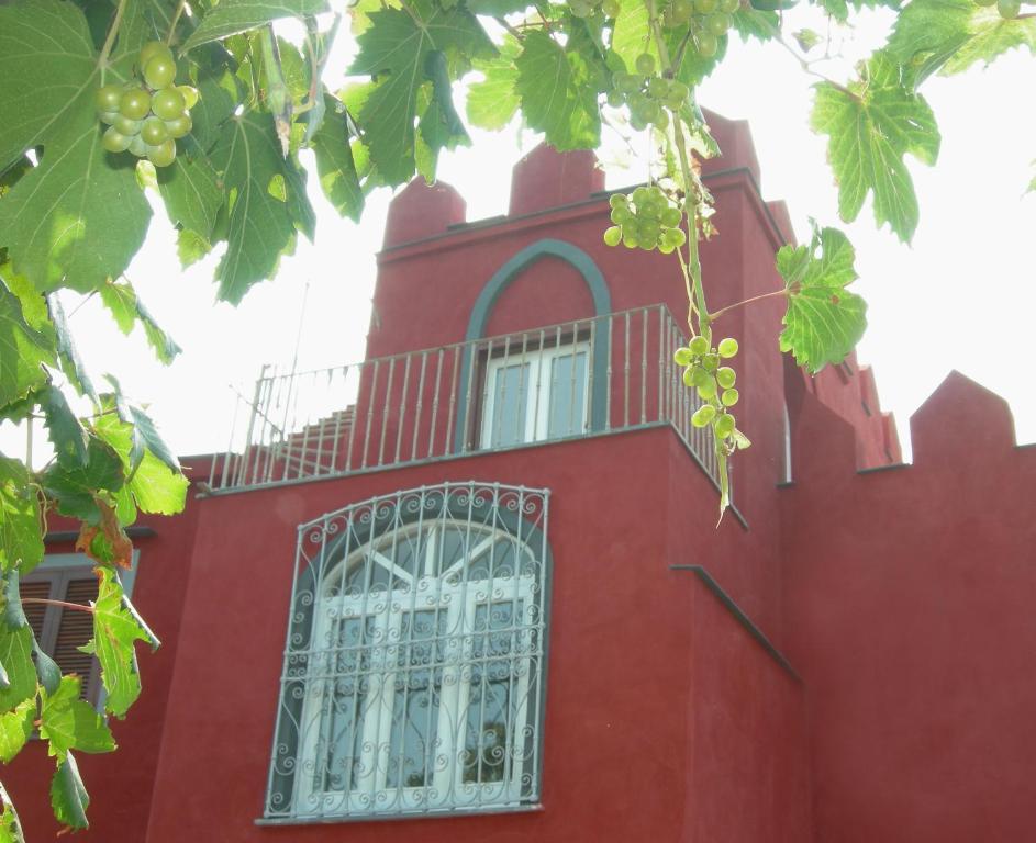 a red building with a window and a bunch of grapes at Albergo 'La Vigna' in Procida