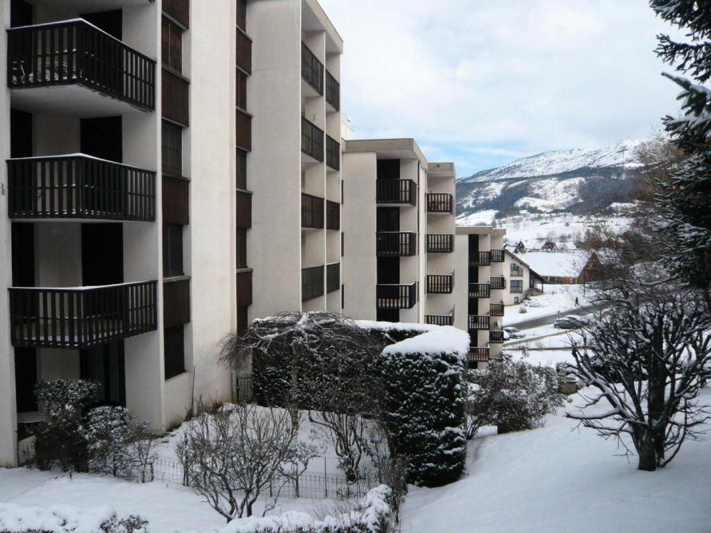 budynek na śniegu z drzewami i krzewami w obiekcie Résidence Les Gemeaux I - Appartement trois pièces au coeur du village MAE-2304 w mieście Villard-de-Lans