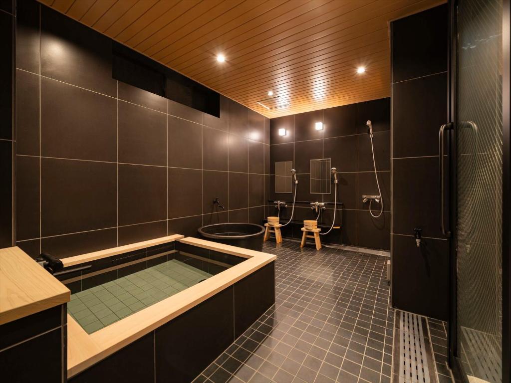 a bathroom with a bath tub and a shower at Ryokan iriya in Tokyo