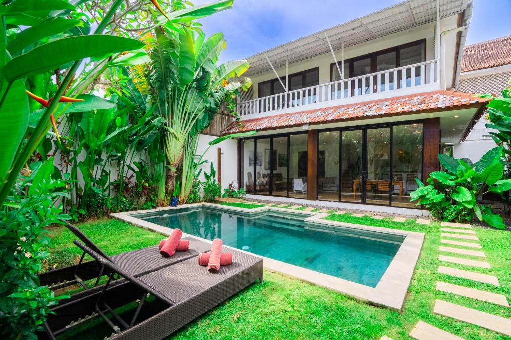 a backyard with a swimming pool and a house at Villas Shiva Complex in Uluwatu
