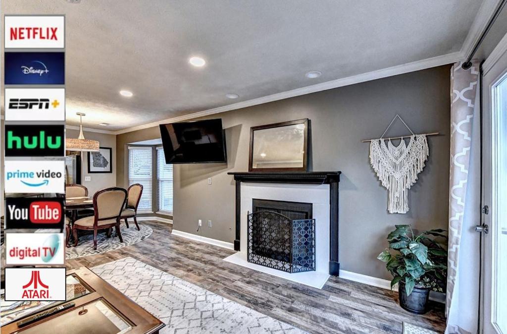 a living room with a fireplace and a tv at Alpharetta Dreaming in Alpharetta