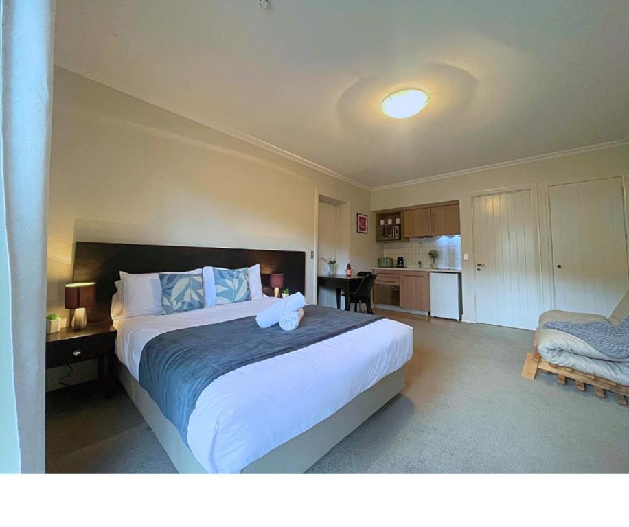 a bedroom with a large bed and a kitchen at Cozy Cardrona Apartment in Cardrona